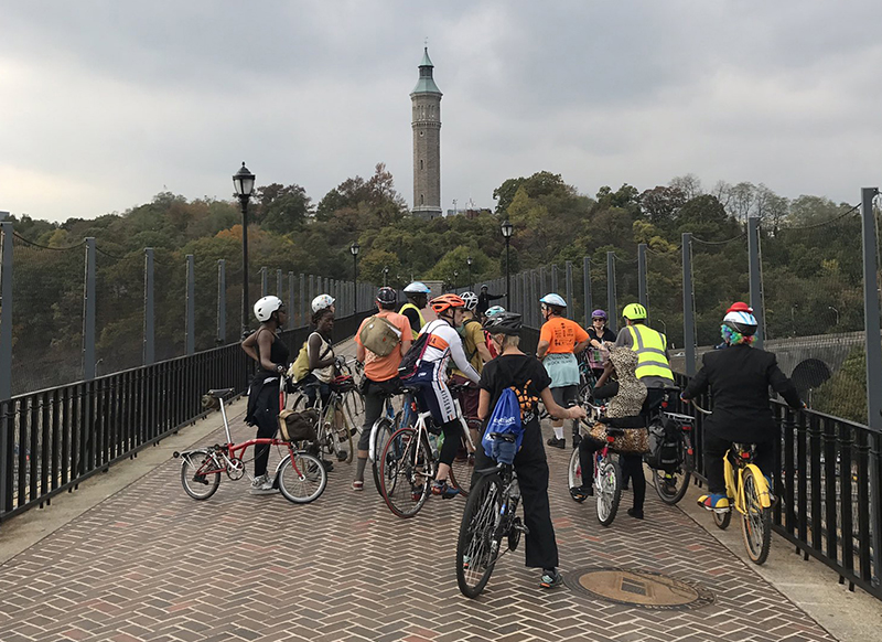 Photo of the Bronx Hallowheel ride stopping on High Bridge for a scary story